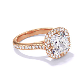 Angled view of an 18K Rose Gold Engagement Ring, featuring a cushion-cut diamond with a wrapped halo three phases pave setting.