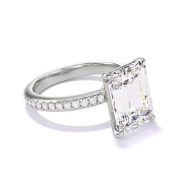 An angled view of an Emerald-Cut Diamond Engagement Ring with a Classic 4-Prong and Three Phases Pave Setting in Platinum.