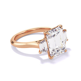 Emerald cut diamond engagement ring with a trapezoid flank three phases slim setting in 18k rose gold