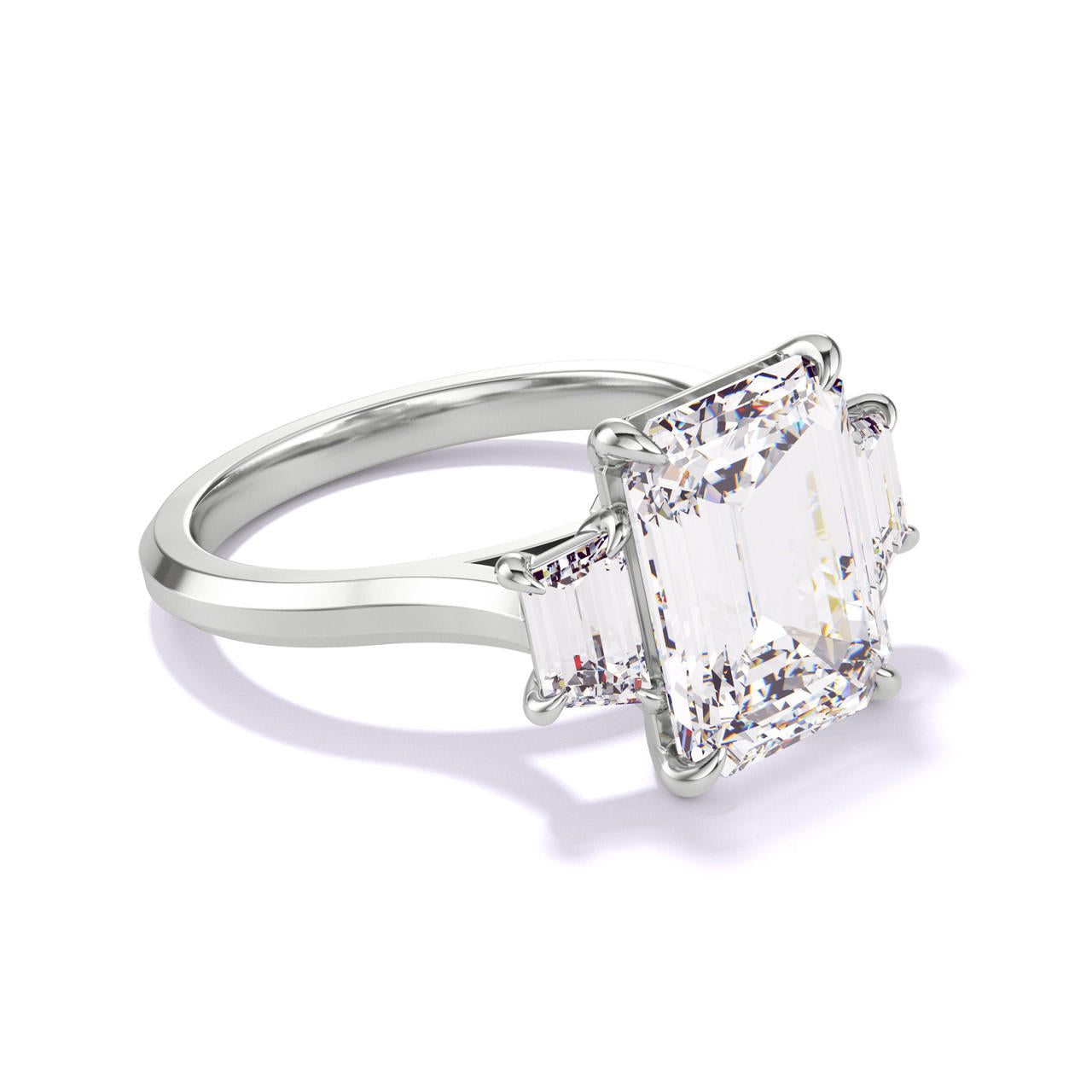 EMERALD CUT DIAMOND ENGAGEMENT RING WITH A TRAPEZOID FLANK THREE PHASES SLIM SETTING IN PLATINUM