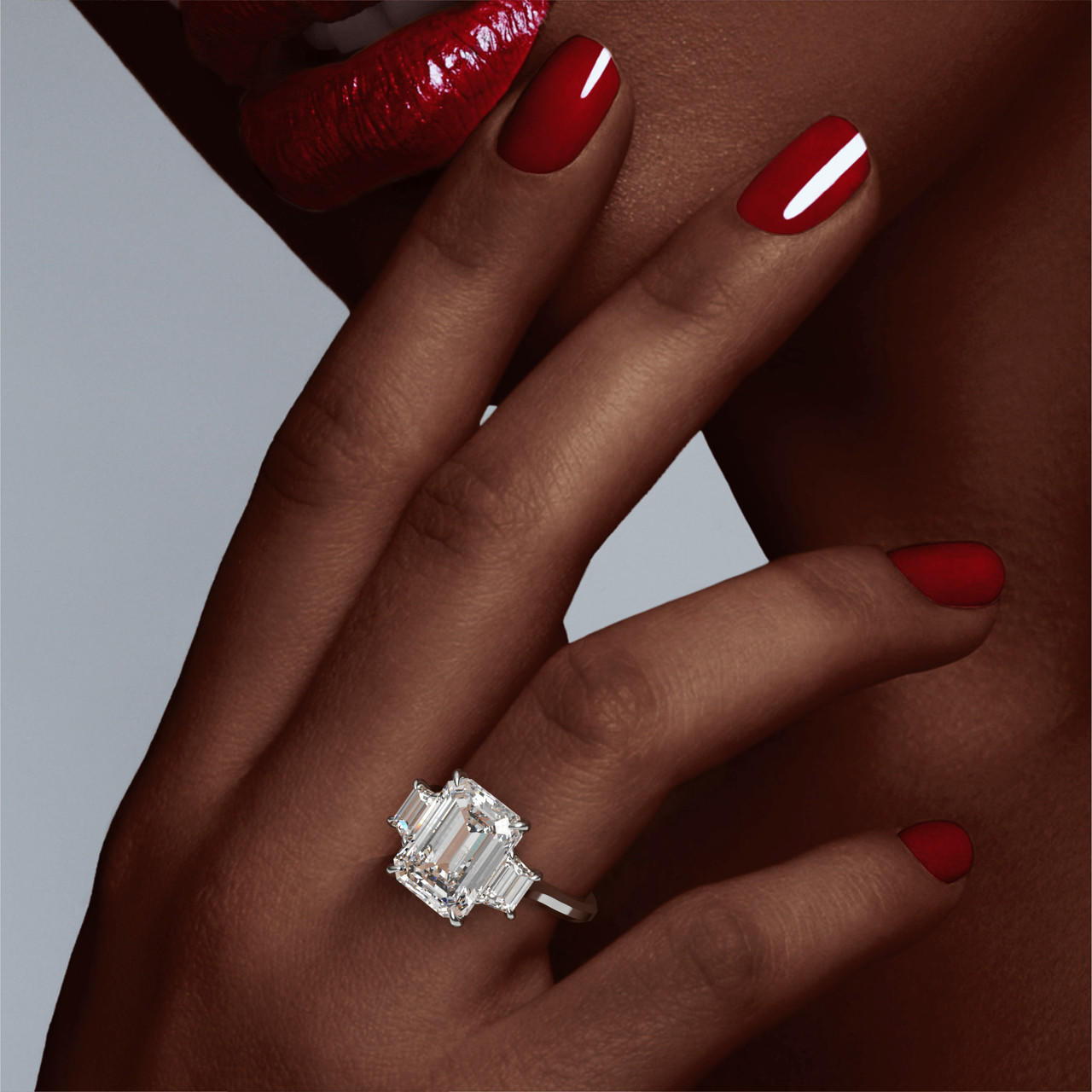 Emerald Cut Trapezoid Flank Engagement Ring on a Slim Three Phases Platinum Band on hand
