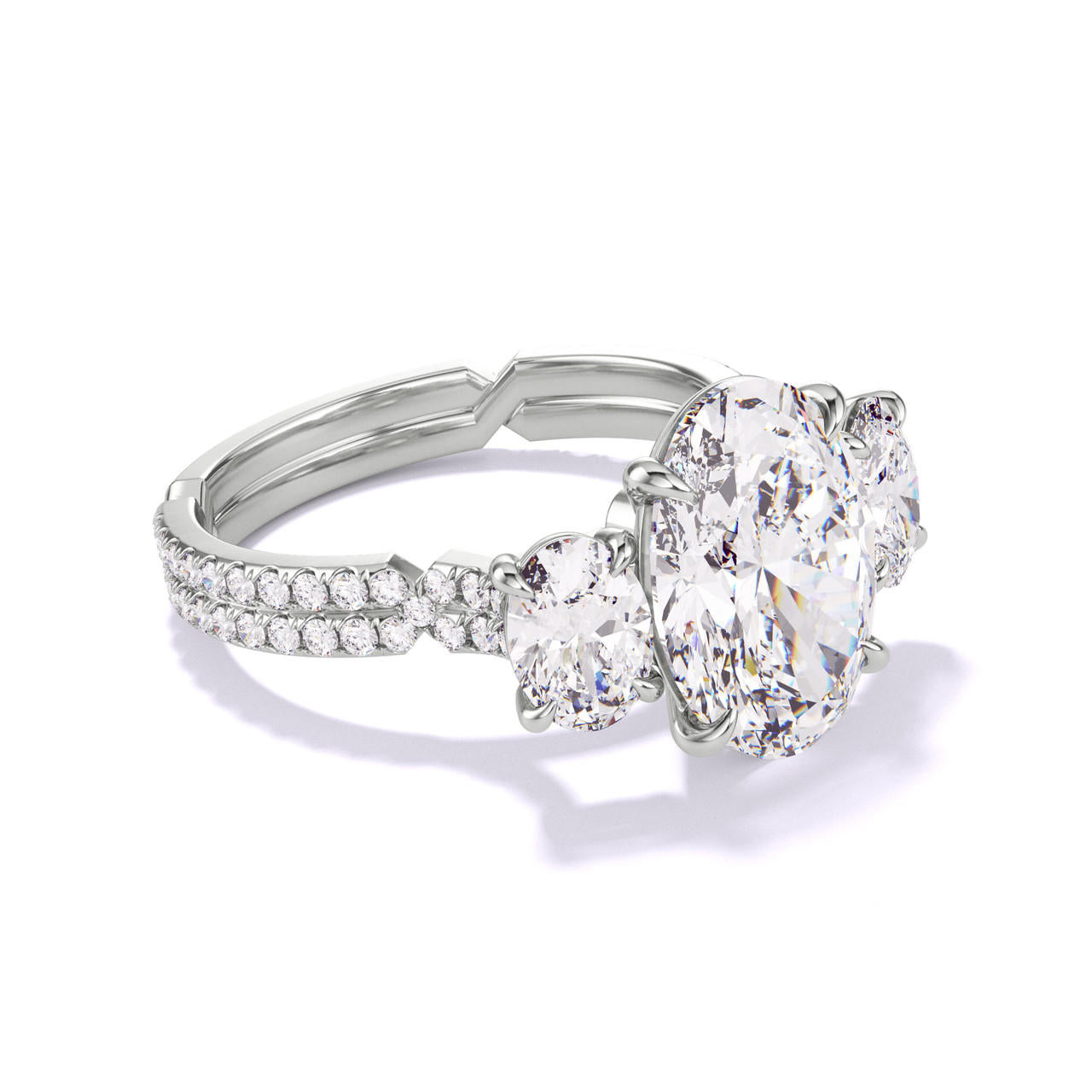 OVAL CUT DIAMOND ENGAGEMENT RING WITH A THREE STONE CHANCE PAVE SETTING IN PLATINUM