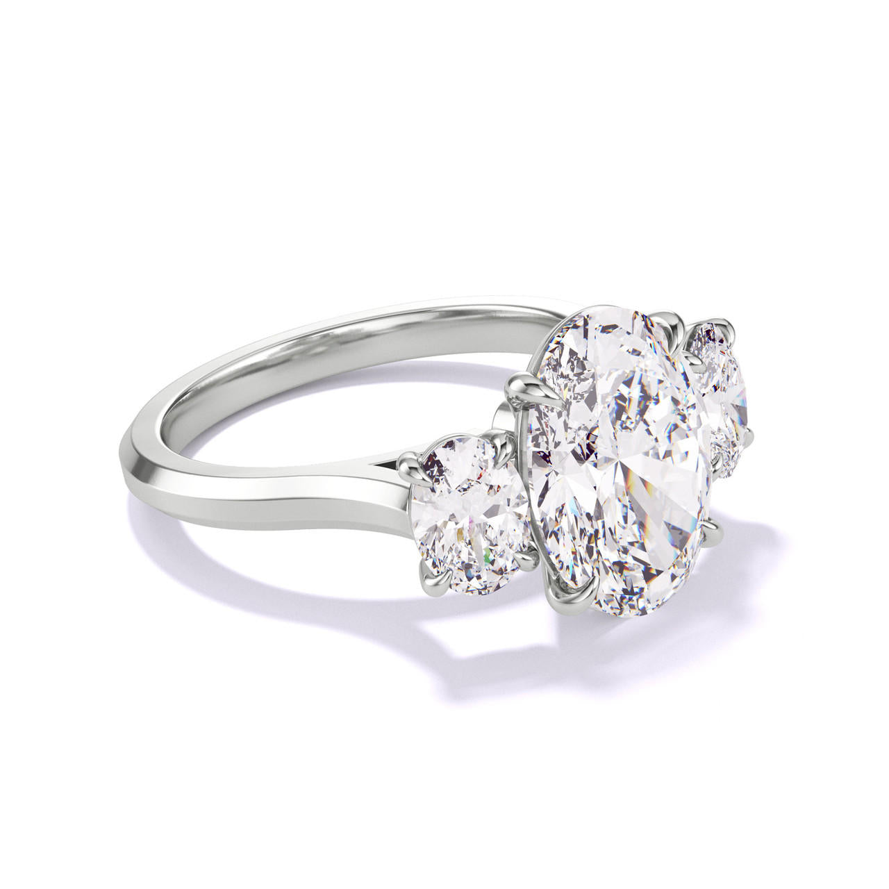 OVAL CUT DIAMOND ENGAGEMENT RING WITH A THREE STONE THREE PHASES SLIM SETTING IN PLATINUM