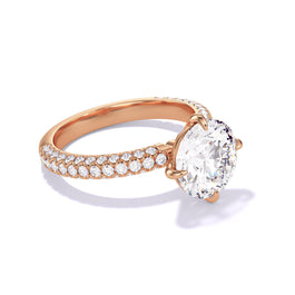 An angled view of the 18K Rose Gold Round Cut Diamond Engagement Ring with a Compass 4 Prong Three Phases Triple Pave Setting.