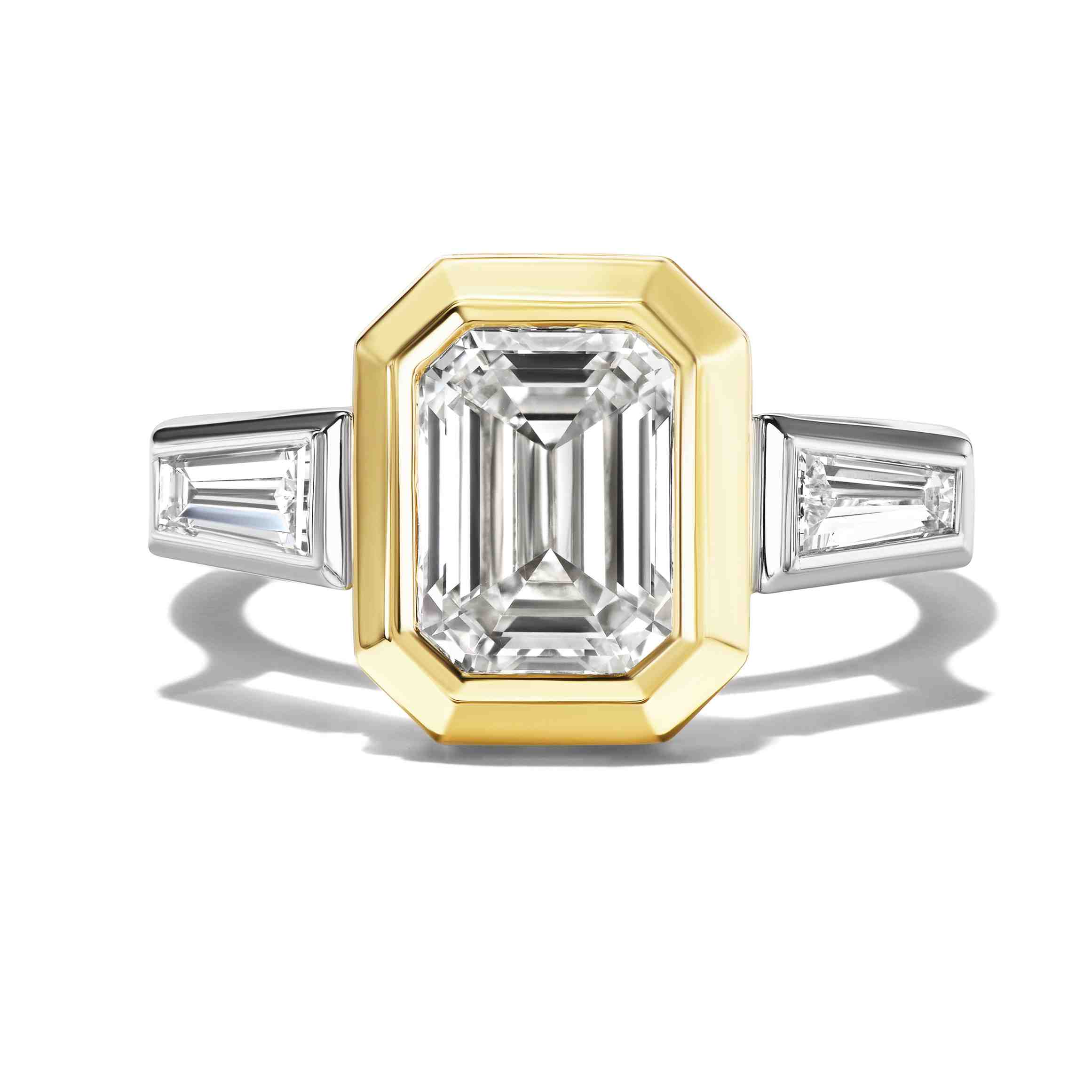 Front view showing an emerald-cut diamond ring paired with two tapered side stones in white and yellow metal.