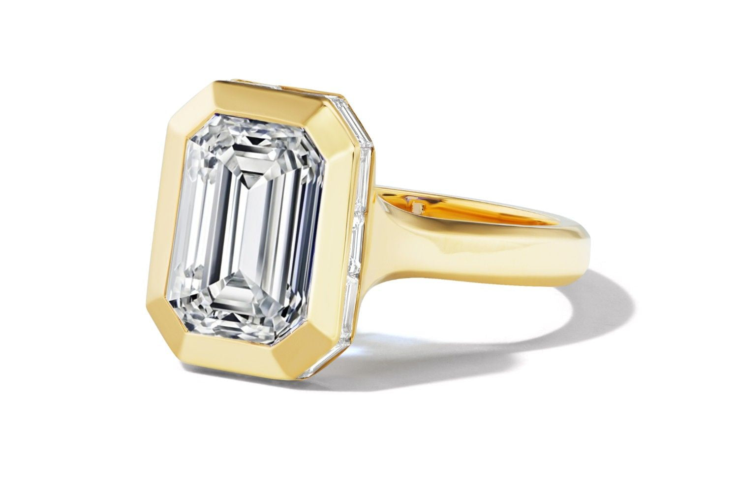 Close-up angled view of an emerald-cut diamond set in a bold yellow gold bezel ring.