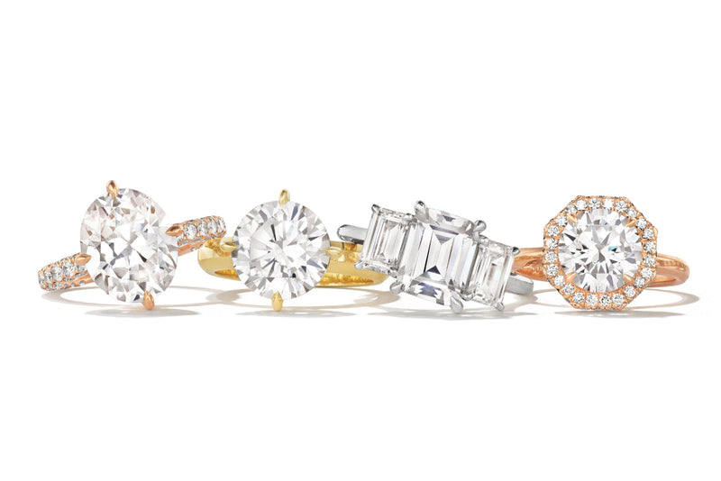 Diamond rings including a rose gold oval, yellow gold round, platinum emerald-cut bezel, and rose gold octagonal design.