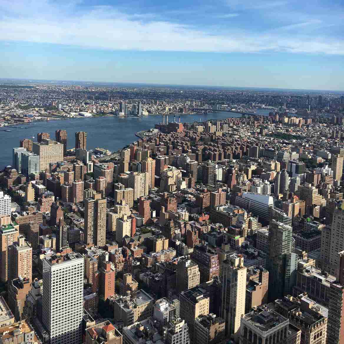Aerial shot of Manhattan’s skyline with the East River and bridges visible in the distance.