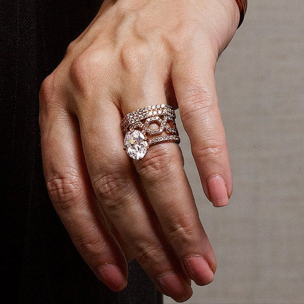 Close-up shot of rose gold diamond rings and pavé wedding bands stacked beautifully on a woman’s ring finger.