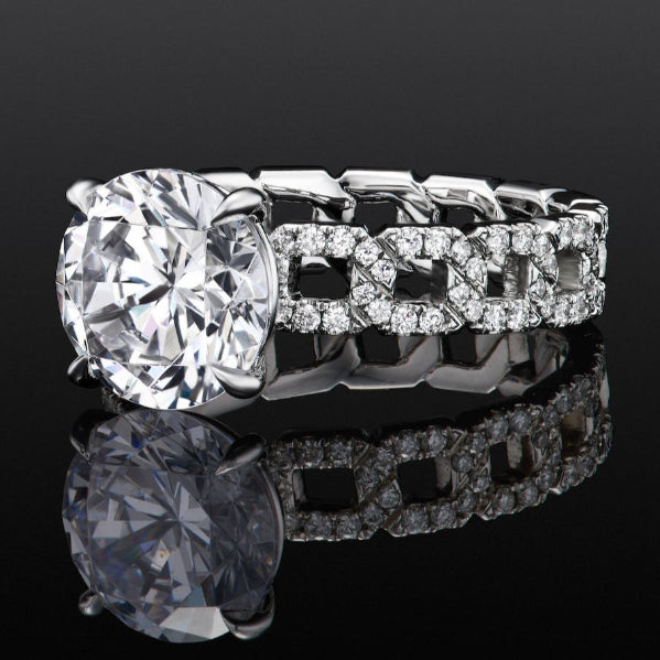 Close-up of a platinum engagement ring with a round diamond and chain-link pavé band on a black reflective surface.