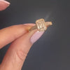 An Emerald-Cut Engagement Ring with Baguettes and Milgrain modeled on a hand.