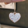 A person holding a Pave Diamond Heart Pendant by Lindsey Scoggins Studio.