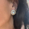 Princess Diana-inspired pearl-and-diamond stud earrings modeled on an ear.