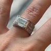 Bezel Set East West Emerald-Cut Diamond Engagement Ring  by Lindsey Scoggins Studio, modeled on a hand.