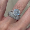 Close-up of a bespoke diamond bridal stack featuring a double halo and wide pave band, modeled on a hand.