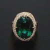 Green tourmaline and diamond flight path ring featuring intricate sweeping gold ribbons.