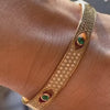 An Emerald and Diamond Evil Eye Bangle by Lindsey Scoggins Studio, modeled on a wrist.